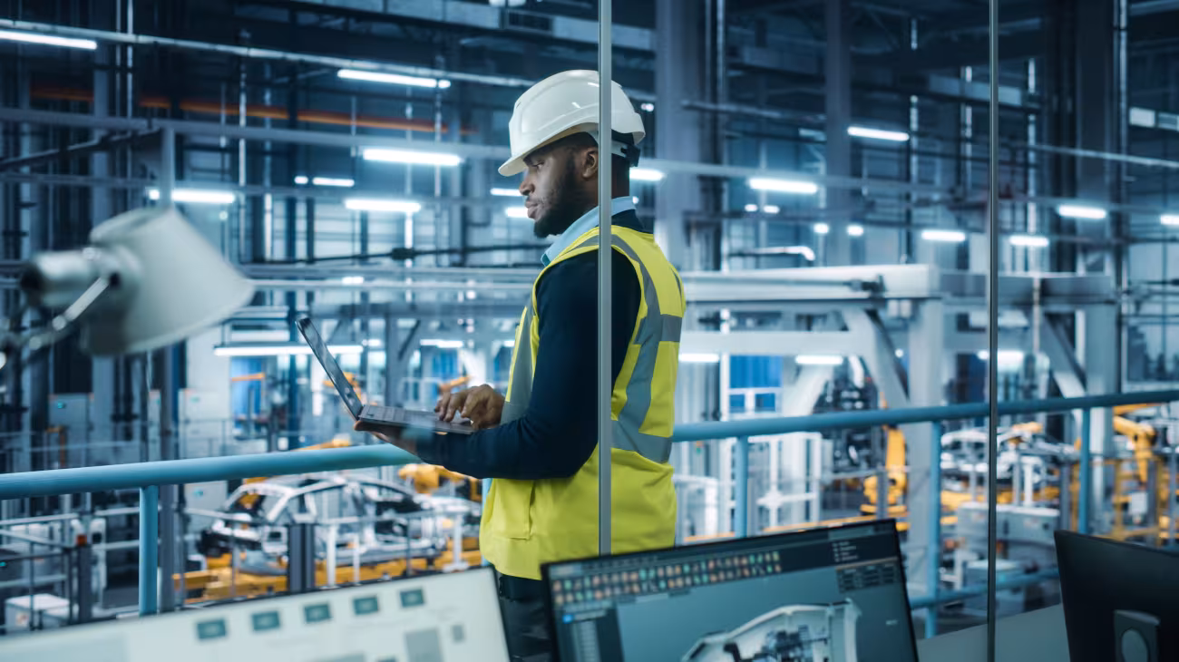 Man in factory holding a laptop